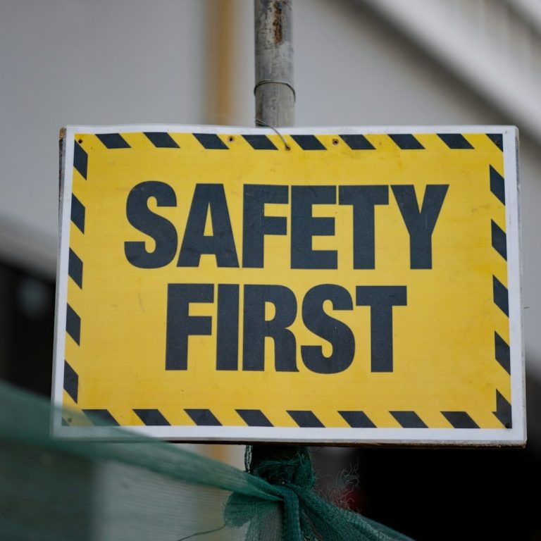 Training Yellow sign with black text reading "SAFETY FIRST" and caution stripes.